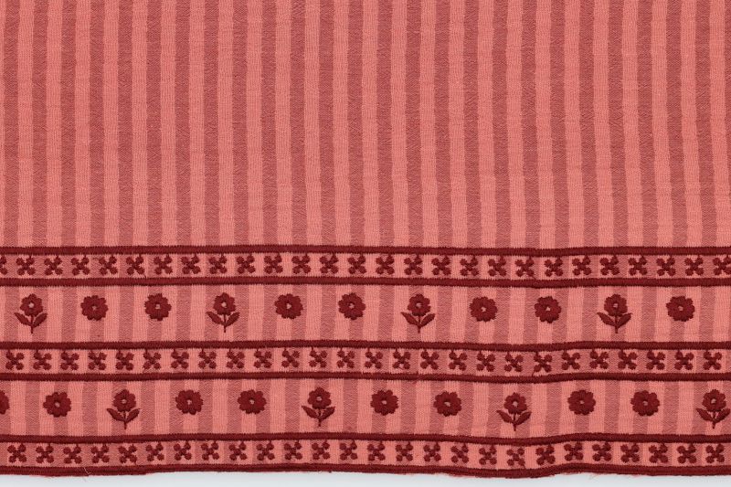 Double gauze stof, streep print met eenzijdige bloemen rand, oranje. A.167-1