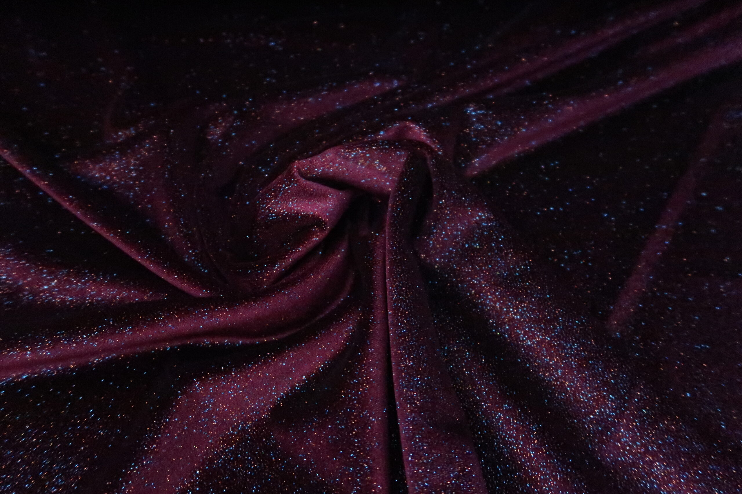 Enzovoorts Stroomopwaarts Zuivelproducten Lycra velours stof in het bordeaux met gekleurde glitters.